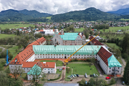 Das Kloster Benediktbeuern nach dem Unwetter aus der Vogelperspektive; die Dächer sind mit türkisblauen und weißen Planen überdeckt.